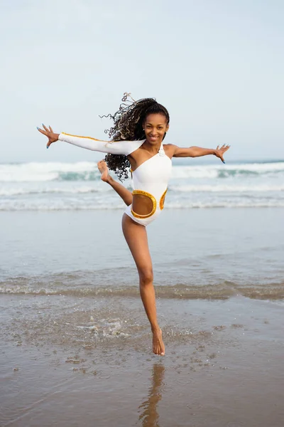 Счастливая женщина танцует на пляже — стоковое фото