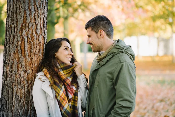 Joven pareja encantadora coqueteando en otoño a pie en el parque — Foto de Stock