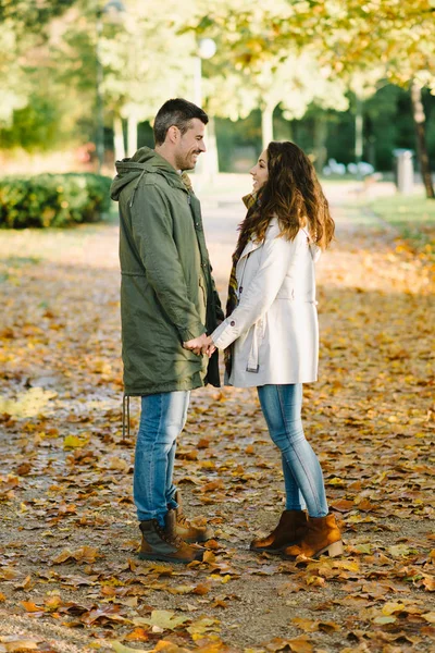 Joven pareja encantadora coqueteando en otoño a pie en el parque — Foto de Stock