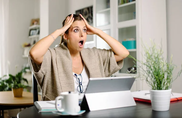 Überraschte Frau macht Fehler bei der Arbeit von zu Hause aus mit Laptop — Stockfoto