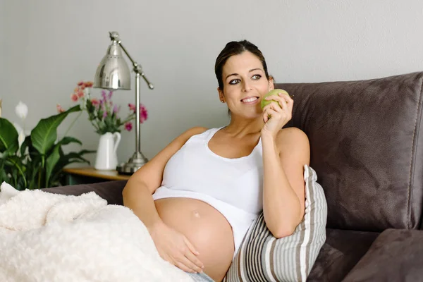 Zwangere rustige vrouw eten en apple thuis — Stockfoto