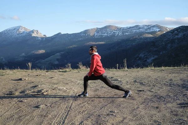 Idrottsman stretching och utövar på berget — Stockfoto