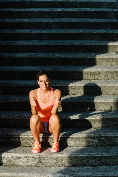 Udanej fitness kobieta siedzi na schodach miejskich — Zdjęcie stockowe