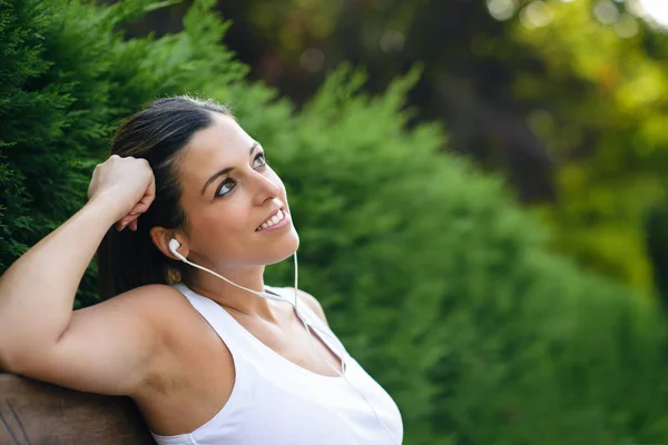 Relaxado mulher desportiva ouvir música e devaneio — Fotografia de Stock