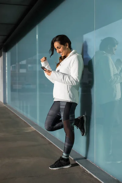 Erfolgreiche Fitness-Frau mit Smartphone — Stockfoto