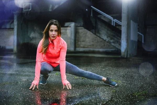 Mujer fitness motivada haciendo ejercicio bajo la lluvia en invierno . —  Fotos de Stock