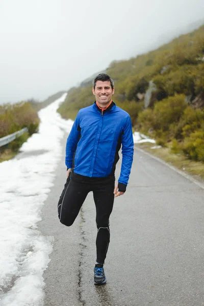 Entrenamiento de atletas y correr en invierno en carretera de montaña — Foto de Stock