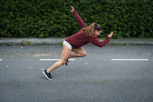 高速強力な若い女性が発芽 アスファルトでの走行訓練 — ストック写真