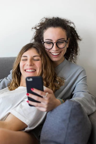 Dos Jovencitas Casuales Felices Que Divierten Usando Smartphone Casa Pareja — Foto de Stock