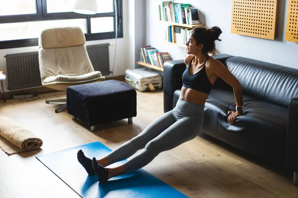 健身锻炼在家里 健康健康的年轻女子在客厅里做三头肌浸泡运动 — 图库照片