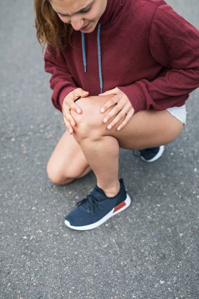 膝を痛めて走る女選手の詳細ページ — ストック写真