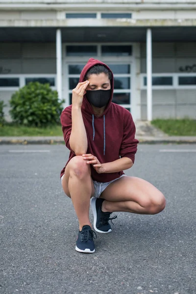 女性ランナーは頭痛がする コロナウイルスの危機の下で健康保護のための顔のマスクを身に着けているスポーティ若い女性 Covid 19症状 — ストック写真