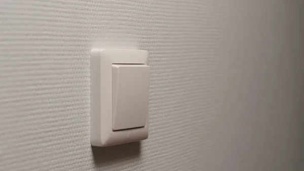 Power button on a light-grey wall