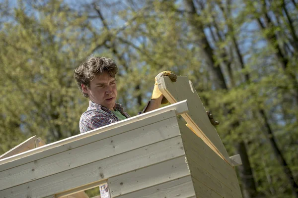 Jeune homme construisant une cabane de jardin — Photo