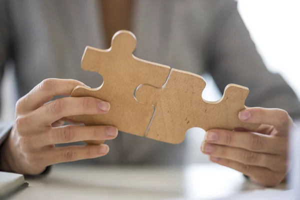 Zár-megjelöl-a kezek összerakva a puzzle-darabokat — Stock Fotó