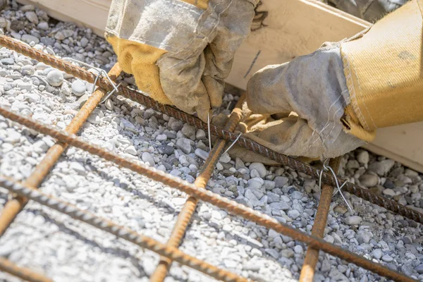 Trabalhador da construção amarrando hastes de reforço de aço — Fotografia de Stock