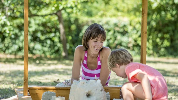 Felice madre che gioca con il suo bambino in giardino — Foto Stock