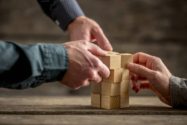 Mani che costruiscono una torre di blocchi di legno — Foto Stock