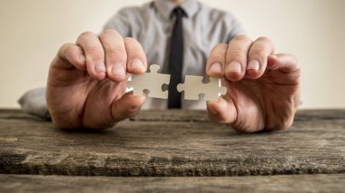 Puzzle parçaları tutan bir iş adamı elinde