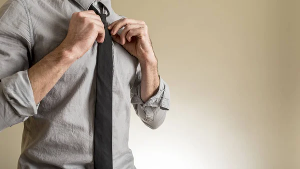 Man adjusting his black necktie — Stock Photo, Image