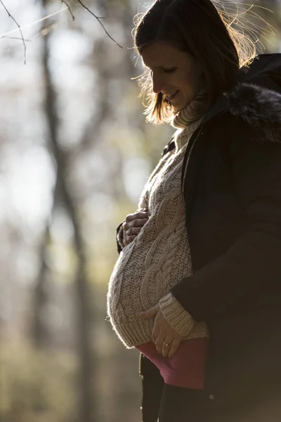 Zwangere jonge vrouw buitenshuis in de herfst — Stockfoto