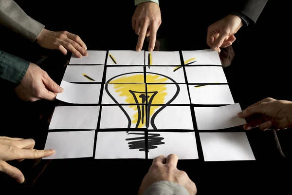 A team of seven businesspeople forming a yellow light bulb — Stock Photo, Image