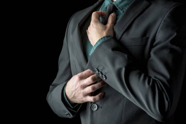 İşadamı yeşil gömlek ve takım elbise onun siyah kravat ayarlama