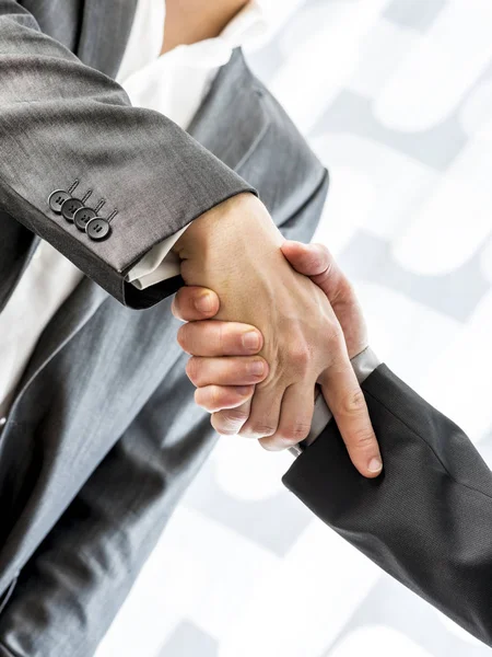 Dos hombres de negocios dando la mano sobre un fondo abstracto borroso —  Fotos de Stock