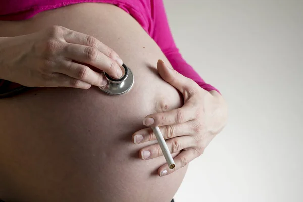 Mujer embarazada sosteniendo cigarrillo — Foto de Stock