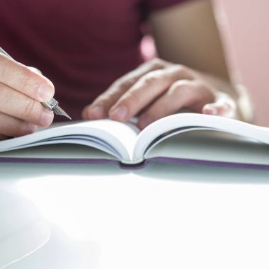 Tatlı bir erkek el üstünde not etmek gümüş kalemle yazma