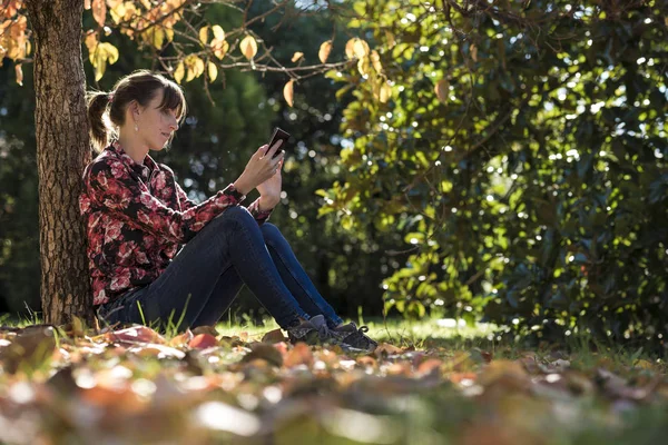 Junge Frau liest etwas auf einem digitalen Gerät — Stockfoto