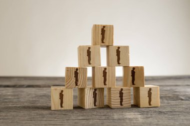 Bir piramit içine yapılandırılmış işadamı siluetleri ile blok