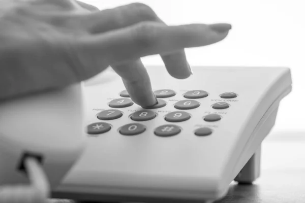 Zwart-wit beeld van vrouwelijke hand een telefoonnummer kiezen op een — Stockfoto