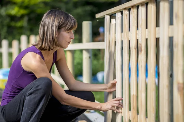 Vrouw gebouw een tuin hek — Stockfoto