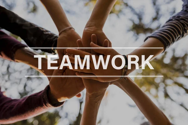 Teamwork-Text über vier Personen, die Hände stapeln — Stockfoto