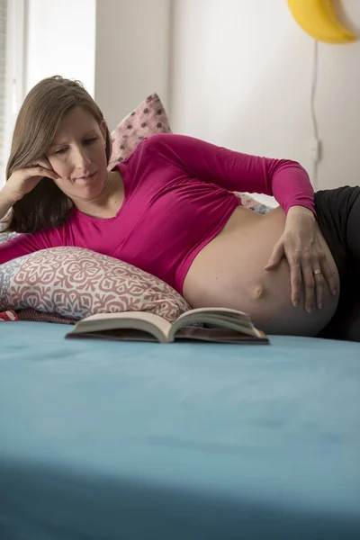 Zwangere vrouw die een boek leest — Stockfoto