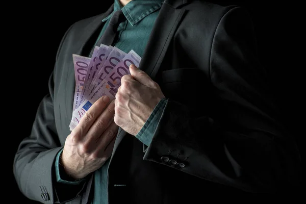 Affärsman i svart kostym holding 500 euro räkningar — Stockfoto