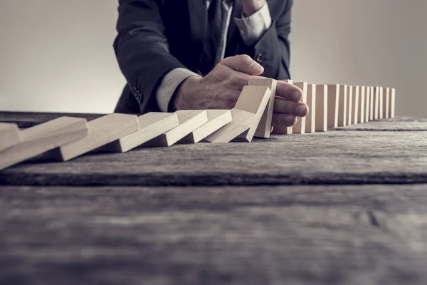 Immagine tonica di un uomo d'affari che ferma l'effetto domino — Foto Stock