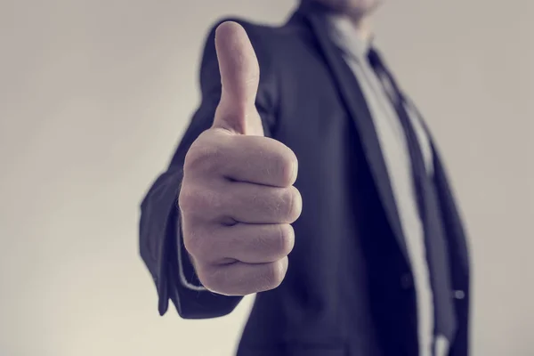 Toned image of businessman showing a thumbs up sign towards you — Stock Photo, Image