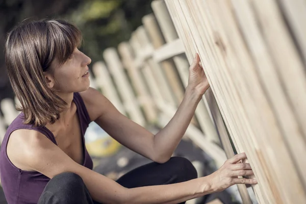 Toned image of a woman building a garden fence — Stock Photo, Image