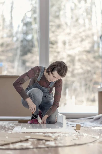Imagen de estilo retro de una mujer montando un mueble de bricolaje en casa —  Fotos de Stock