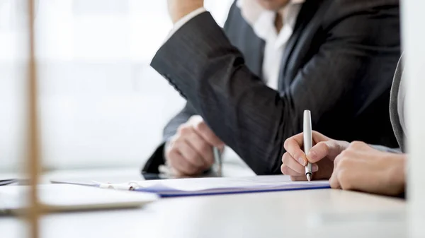 Geschäftspartner prüfen ein Dokument, während sie es unterzeichnen — Stockfoto