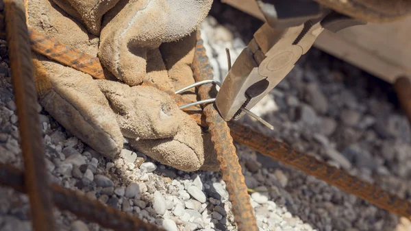 Closeup of a man making a net of steel bars by clipping them tog — Stock Photo, Image