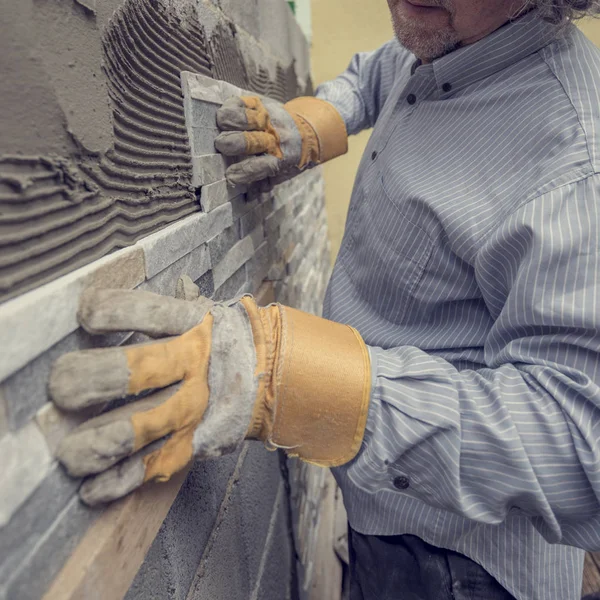 Worker pushing the tile into the cement on the wall — Stock Photo, Image