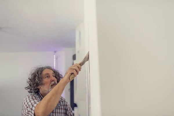 Side view of a man plastering a wall — Stock Photo, Image