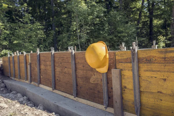 Conceito de canteiro de obras com um chapéu duro amarelo brilhante — Fotografia de Stock