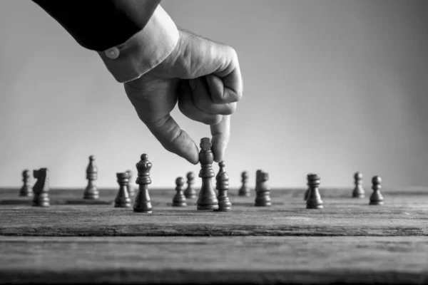 Ο άνθρωπος με το επαγγελματικό κοστούμι παίζοντας σκάκι κινείται ο βασιλιάς κομμάτι — Φωτογραφία Αρχείου