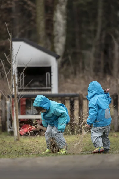 Dvě děti si hrají v louži — Stock fotografie