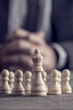 Kraliçe satranç f önünde oturan sıktı elleri ile işadamı