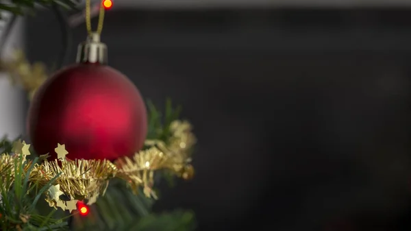 Bauble vermelho em uma árvore de Natal decorada com ouropel espumante — Fotografia de Stock